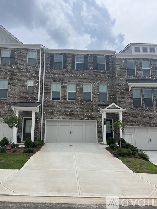 A two-story brick apartment building with a white garage door.