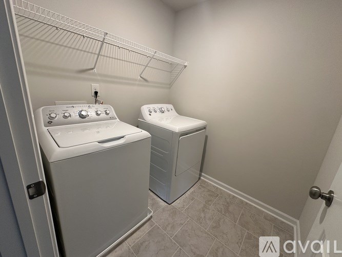 A small laundry room with a washer and dryer.