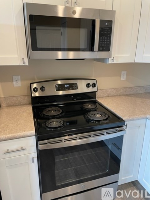 A modern kitchen with a stove top oven and microwave above it.