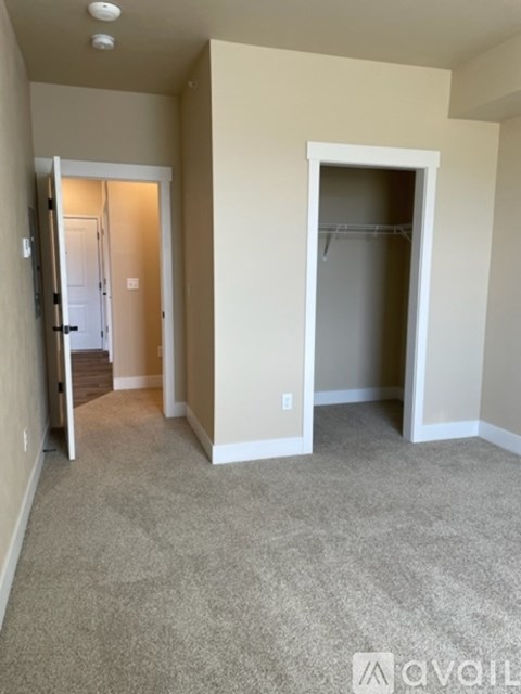 A room with a carpeted floor and two open doors.
