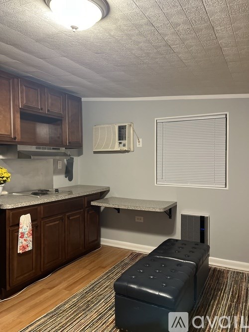 A kitchen with a microwave, oven, and a bench.