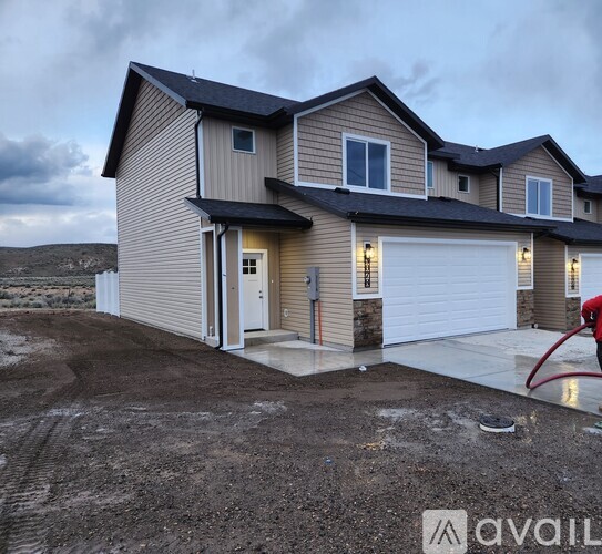 A house with a garage and a driveway in front of it.