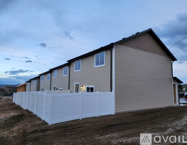 A row of houses with a white fence in front.