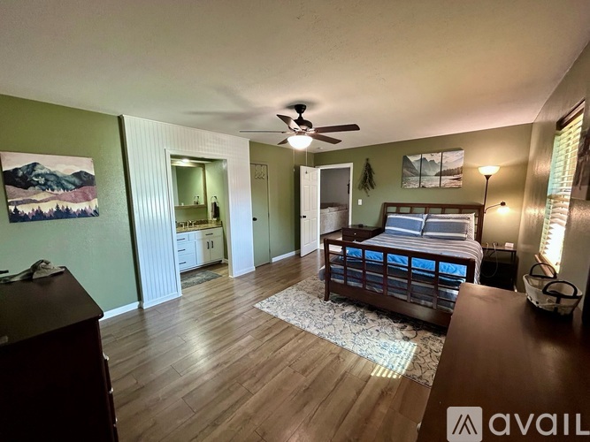 A bedroom with a bed, dresser, and mirror.