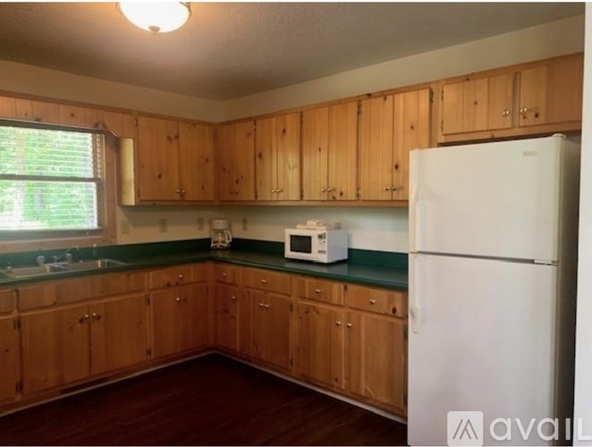 A kitchen with wooden cabinets and a white fridge.