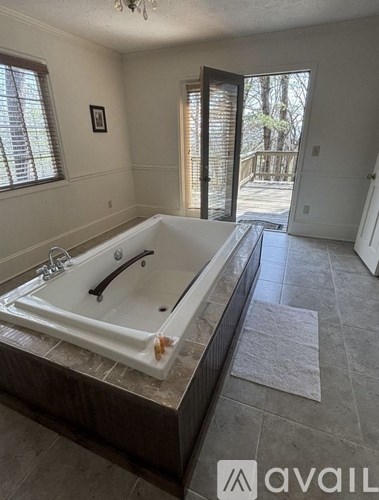 A bathroom with a tub and a window.