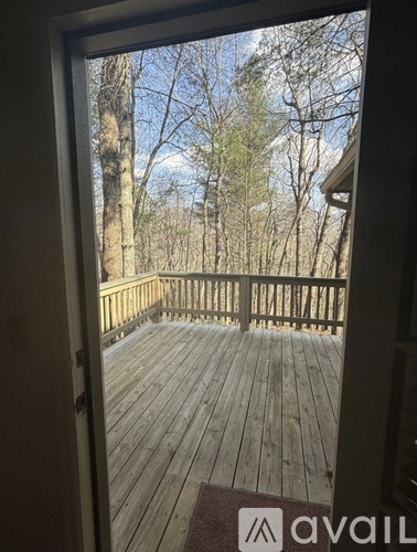A wooden deck with a view of trees and sky.