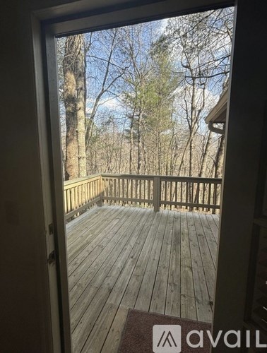A wooden deck with a view of trees and sky.
