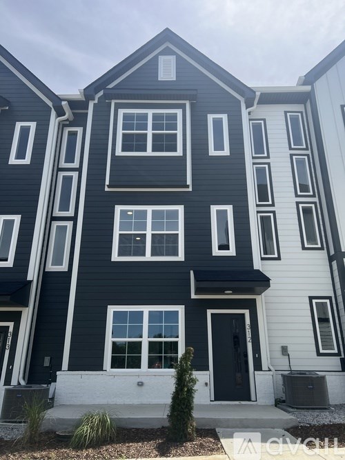 A modern two-story building with a black and white exterior.