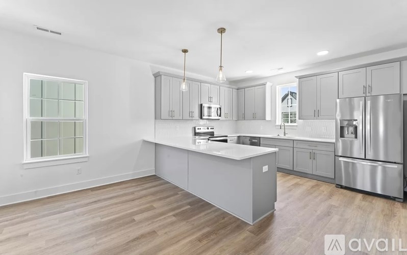 A kitchen with a white countertop and stainless steel appliances.