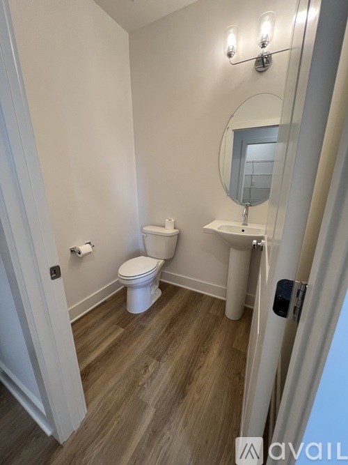 A bathroom with a toilet, sink, and mirror.