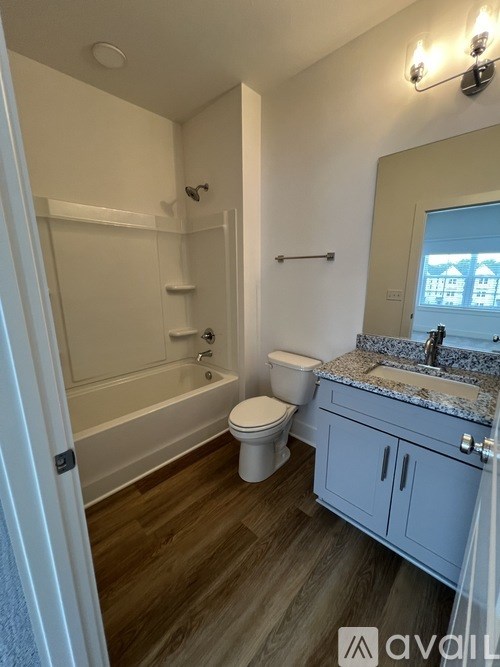 A bathroom with a toilet, sink, and bathtub.