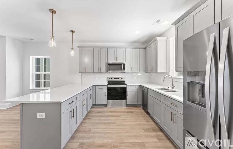 A modern kitchen with stainless steel appliances and wooden floors.