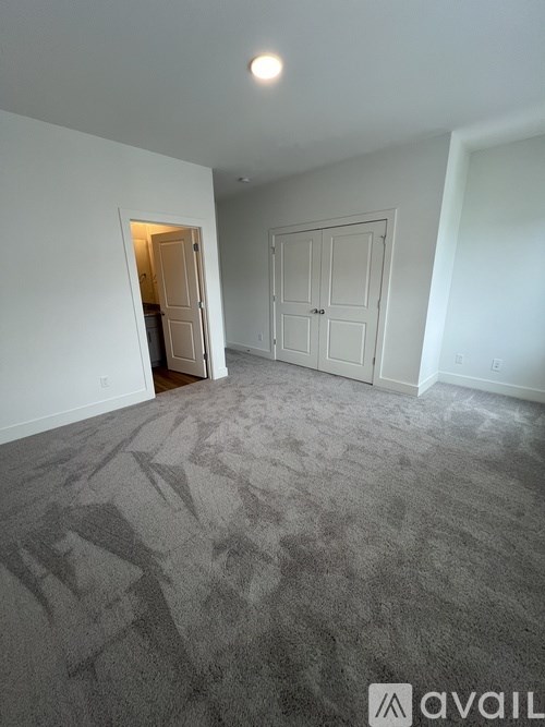 A room with a grey carpet and a white door.