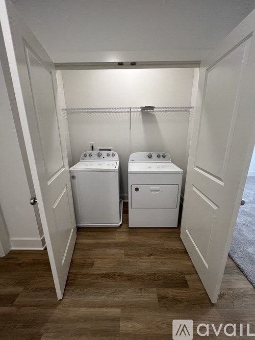 A laundry room with two washing machines and a small shelf above the dryer.
