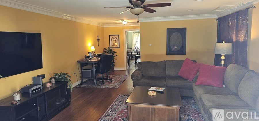 A living room with a grey couch and a black television.