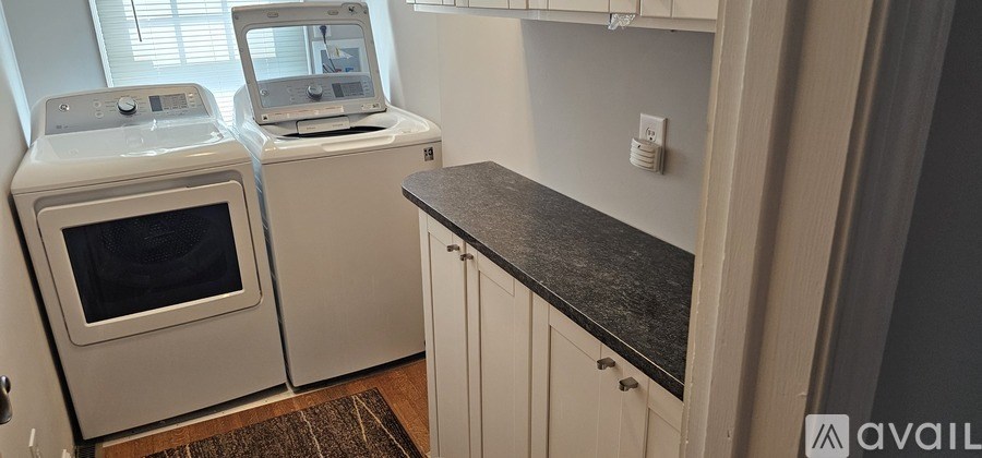 A small kitchen with a washing machine and a microwave.
