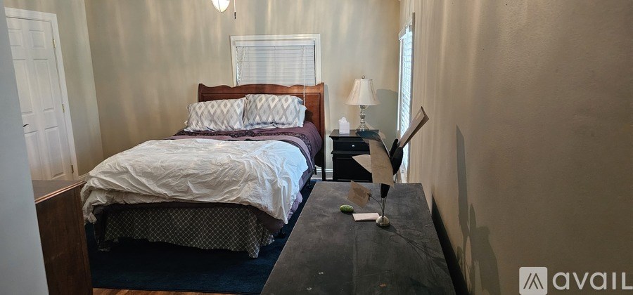 A bedroom with a bed, nightstand, and lamp.