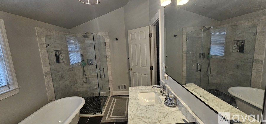 A bathroom with a white tub and marble countertop.