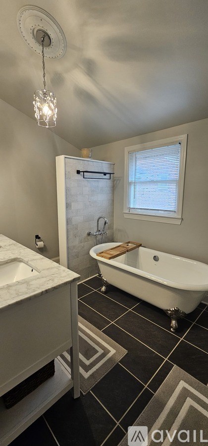 A bathroom with a white tub and a window.