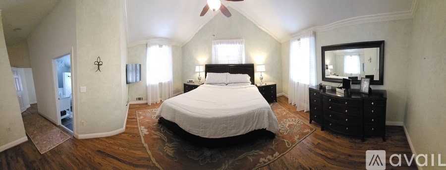 A bedroom with a large bed and a dresser with a mirror.