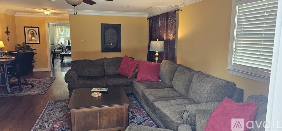 A living room with a grey couch and a brown coffee table.