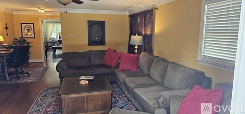 A living room with a grey couch and a brown coffee table.
