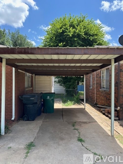 A covered patio area with a white roof and a brick wall.