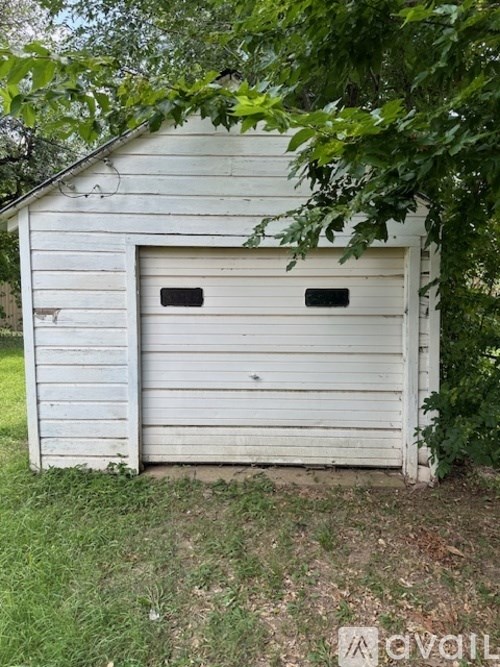 A white garage door is closed and has a small window above it.