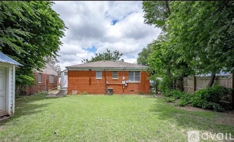A red brick house with a white door and a green lawn.