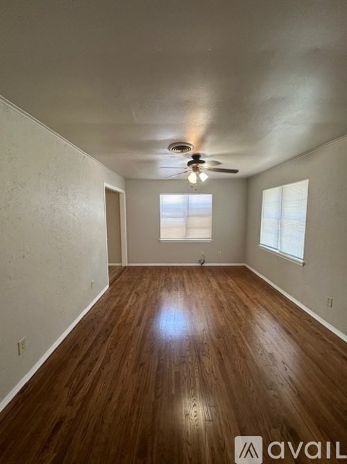 A room with wooden floors and a ceiling fan.
