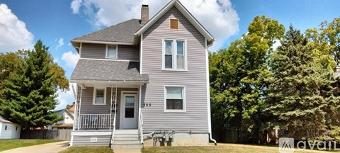 A two-story house with a grey exterior and a white door.
