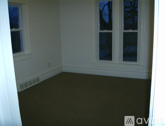 A room with a carpeted floor and a window.