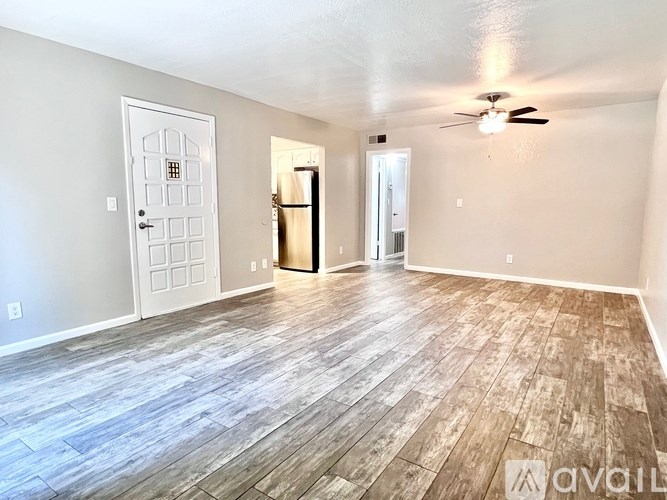 A room with wood flooring and a ceiling fan.