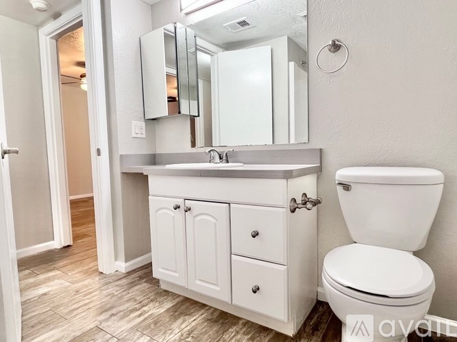 A white bathroom with a toilet, sink, and medicine cabinet.