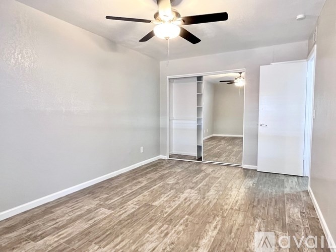 A room with a ceiling fan and a sliding door.