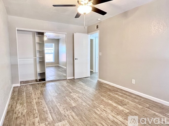 A room with a ceiling fan and sliding glass doors.
