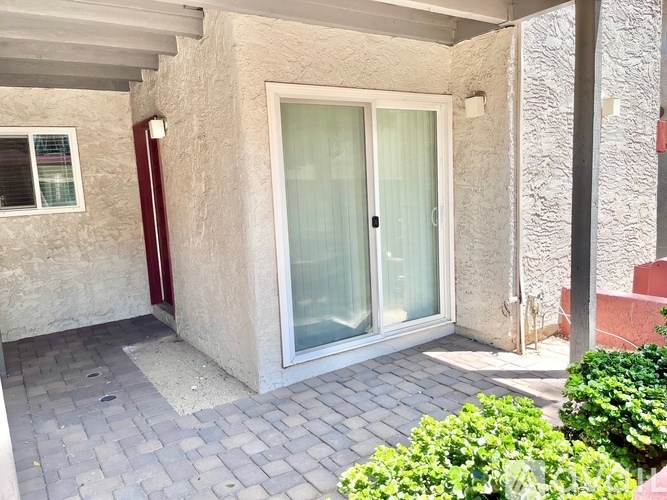 A patio area with a glass door and a window.