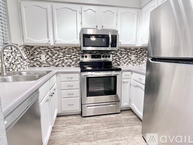 A kitchen with white cabinets and a black and silver stove.