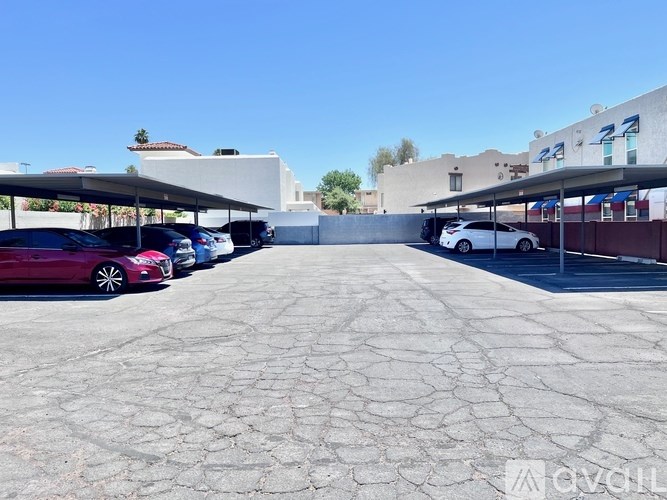 A parking lot with cars parked under a canopy.