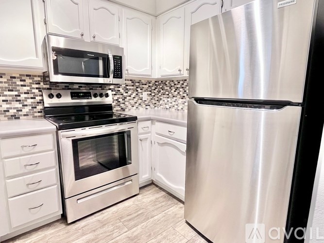 A kitchen with a stainless steel refrigerator, oven, and microwave.