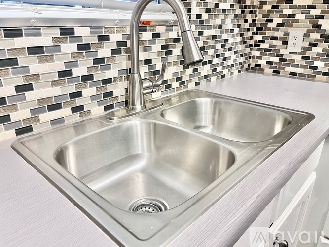 A stainless steel kitchen sink with a chrome faucet.