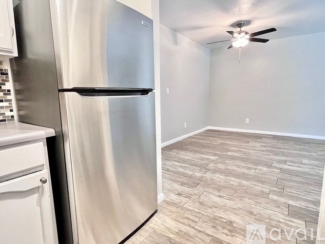 A kitchen with a stainless steel refrigerator and a ceiling fan.