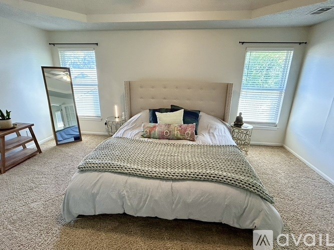 A bedroom with a large bed and a carpeted floor.