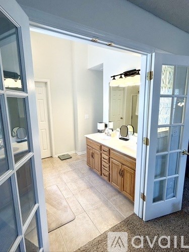 A bathroom with a sink, mirror, and cabinets.