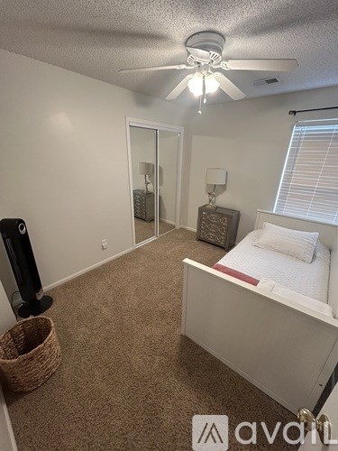 A bedroom with a bed, dresser, and mirror.