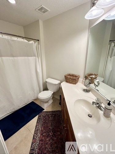 A bathroom with a toilet, sink, and shower.