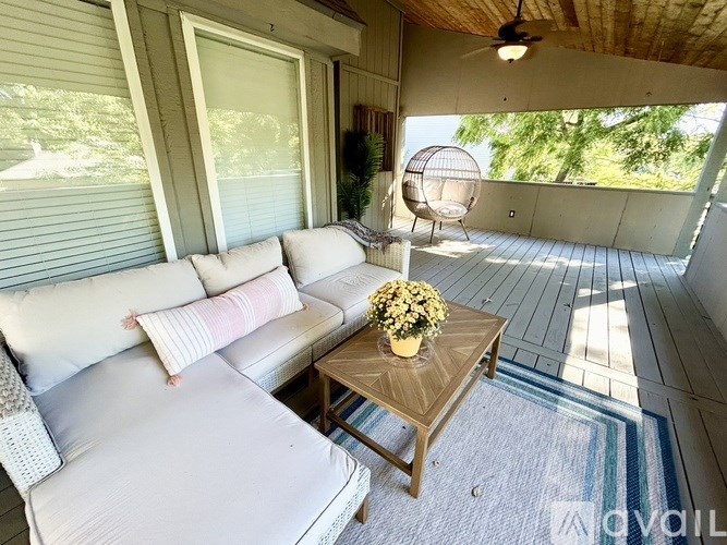 A white couch with a wooden coffee table in front of a window.