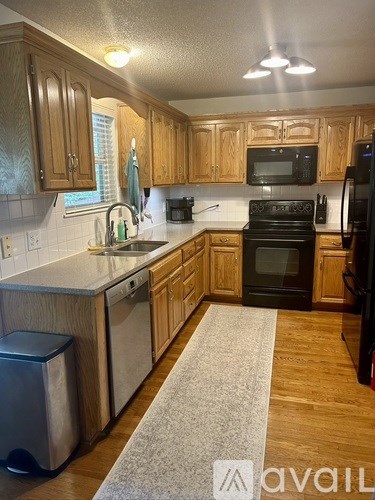 A kitchen with wooden cabinets and a black stove top oven.
