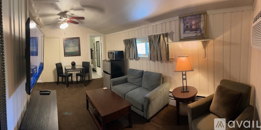 A living room with a couch, chair, and television.